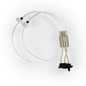 Medical tubing and connector assembly: two clear flexible tubes connect to a small white plastic connector and a compact valve module with a black mounting base.